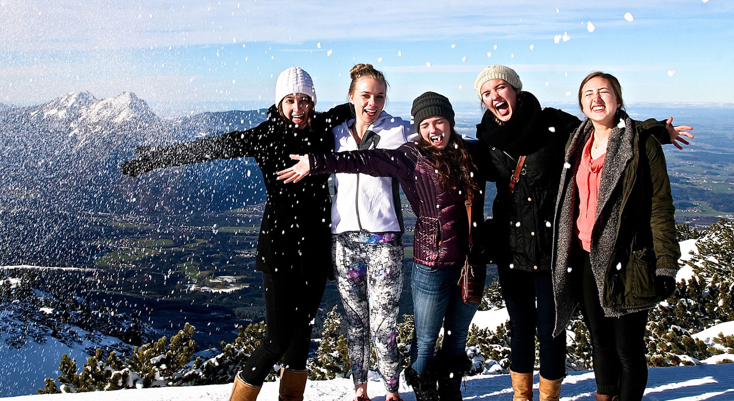 Four students on top of a snowy mountain in Austria.