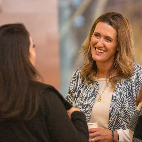 Amanda Higgins speaking with an attendee at her spring Wine Lecture Series.