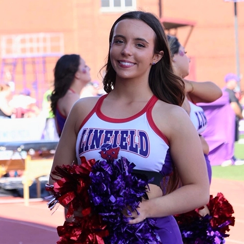photo of Ava cheering at a football game.