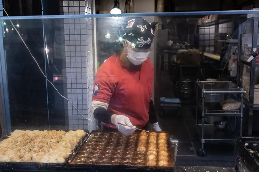 a street vendor preparing the takoyaki.