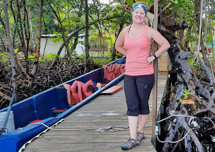 Cassandra standing on a dock in Panama by a boart