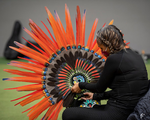 Performer at Linfield's annual Hispanic Heritage Celebracion holding a head dress.