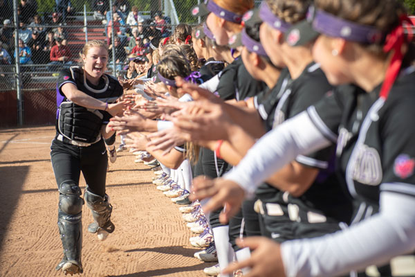 Kamryn as catcher getting high fives from teammates