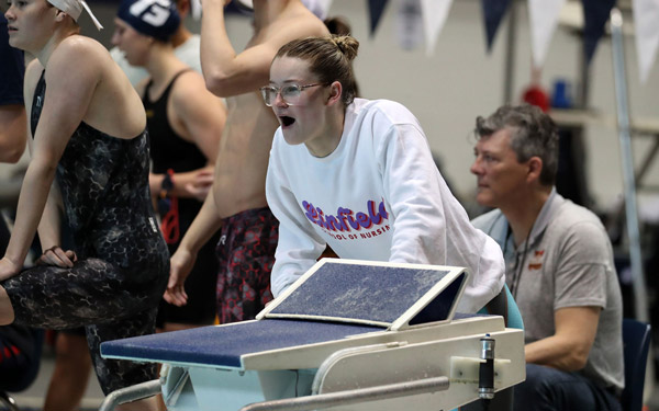 Maggie cheering on her teammates at a swim meet.