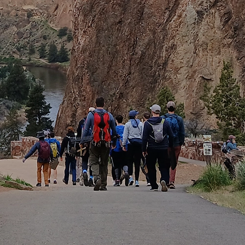 The group of volunteers walking on a path toward Smith Rock.