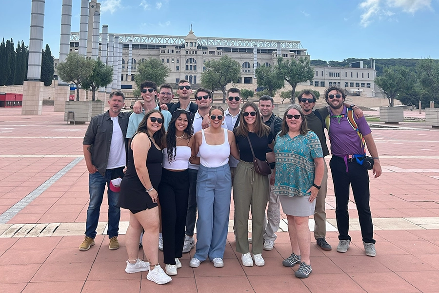 MS in business cohort posing in front of a building in Barcelona.