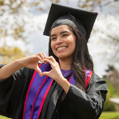 nursing graduate making the shape of a heart with her hands