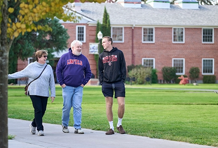Family walks on campus in Linfield gear