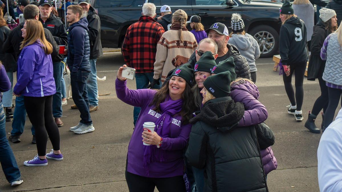 Group of fans take a group picture at a football tailgate