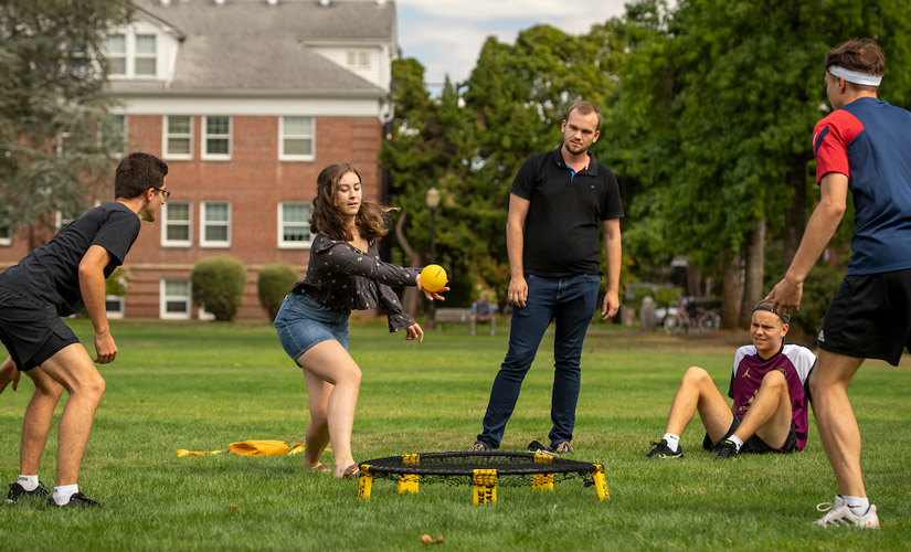 five students playing a lawn game during orientation on the IM field