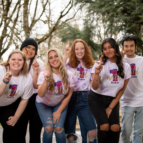 Six Linfield students gesturing "number 1" in excitement.