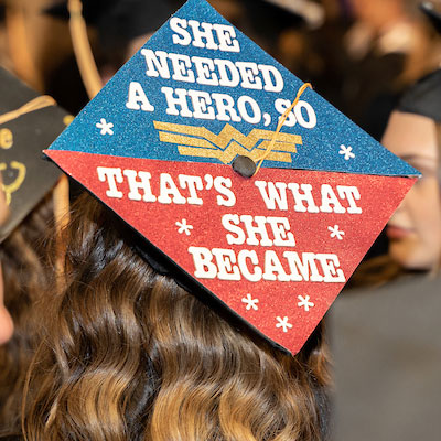 a graduate's cap reading "she needed a hero so she became one."