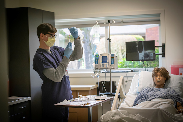 male nursing student practicing on manikin