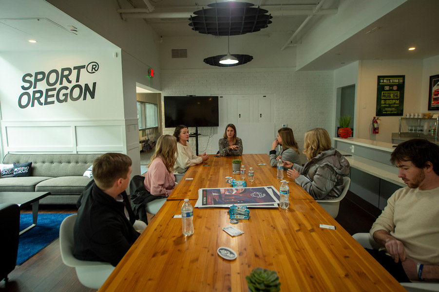 Students on a field trip at Sport Oregon sitting around a conference table with executive.