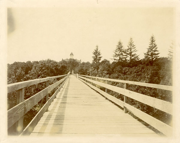 the old entrance to the college with Pioneer Hall visible at the end of the bridge