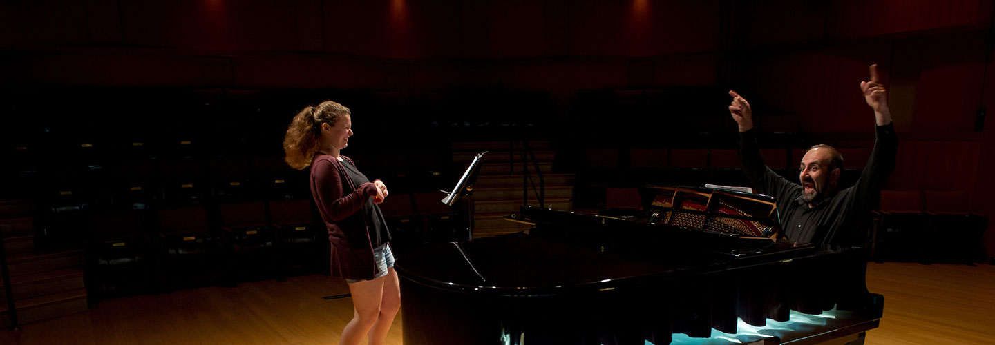 Professor and student around piano