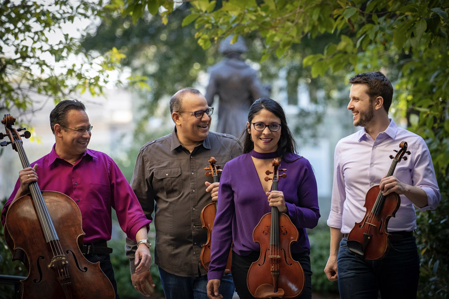 Four members of the Dali Quartet holding their instruments. Photo credit: Ryan Brandenberg.