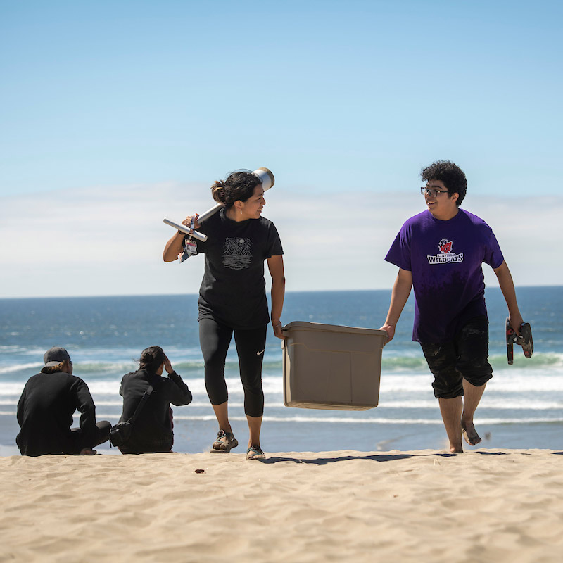 Two students participating in research at the Oregon coast for a science class.