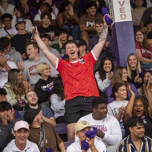 student cheering in the football stands during Cat Camp.