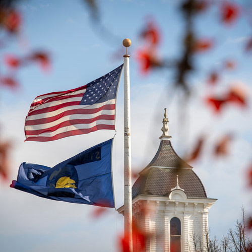 The U.S. flag and Oregon flag flying over Pioneer Hall