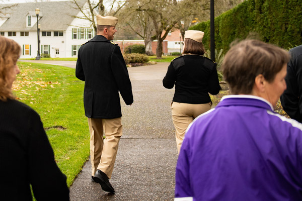 Professor Schuck walking with a Navy officer on campus