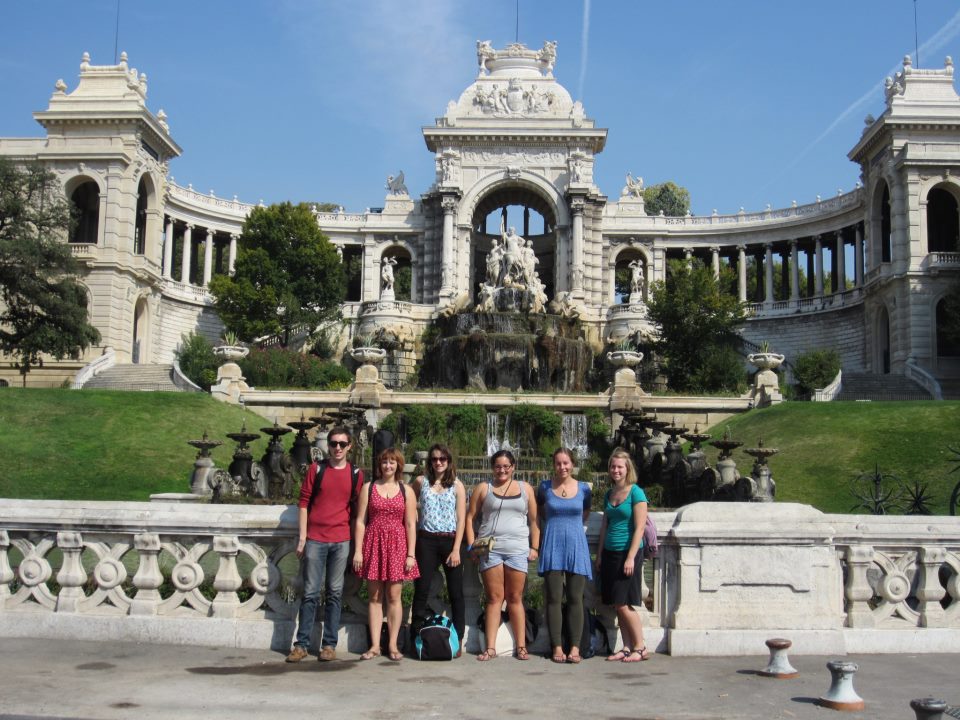 Students standing in front of a French monument.