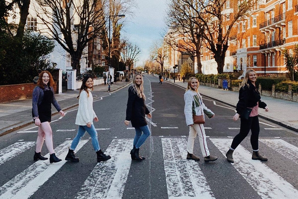 Five female students walking crosswalk on Abby Road, London, England