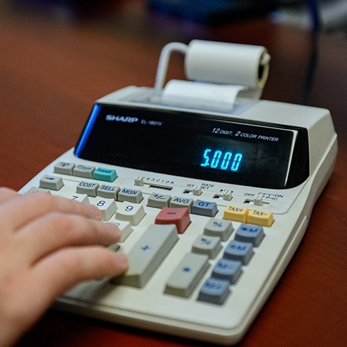 Close up of a person using a calculator.