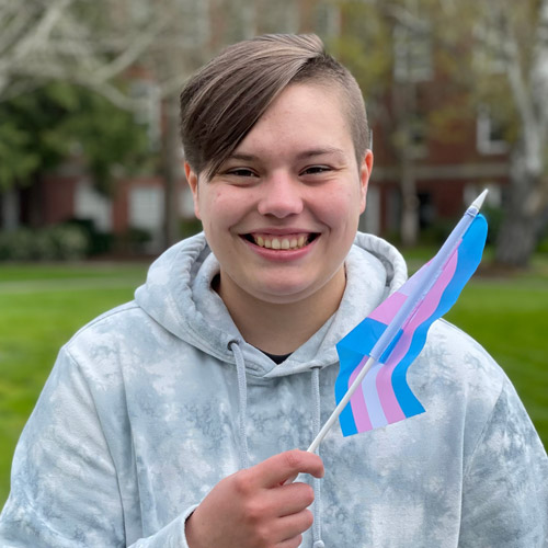 student portrait holding pride flag