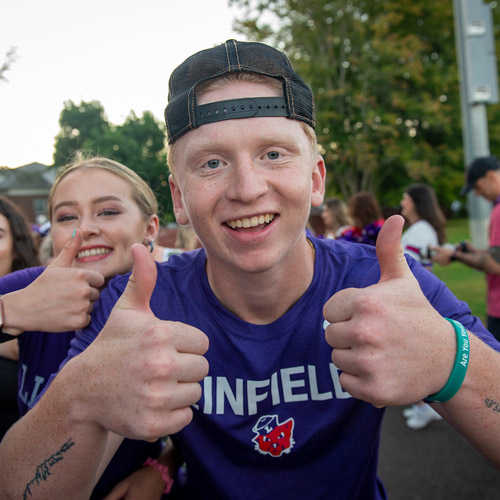 two students giving two thumbs up