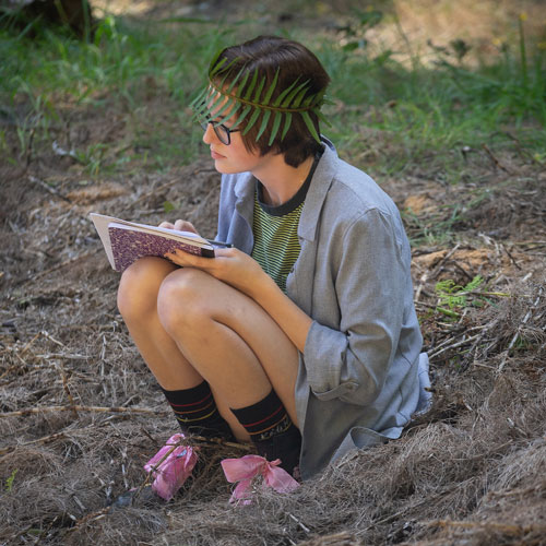 student writing in the woods