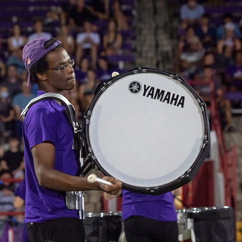 Student performing on drums in the Marching Band