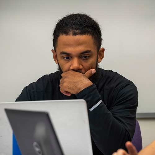 student in class studying on a laptop