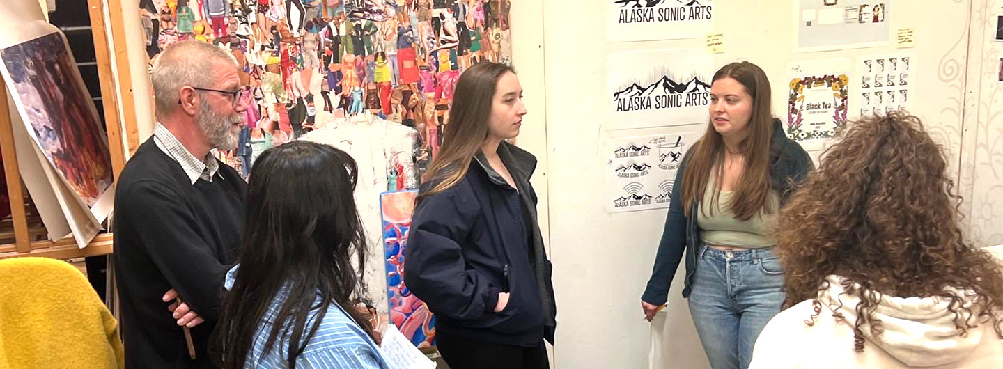 Professor Brian Winkenweder speaking to a group of art students.
