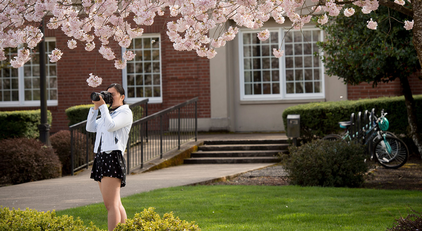 student photographing campus in spring bloom