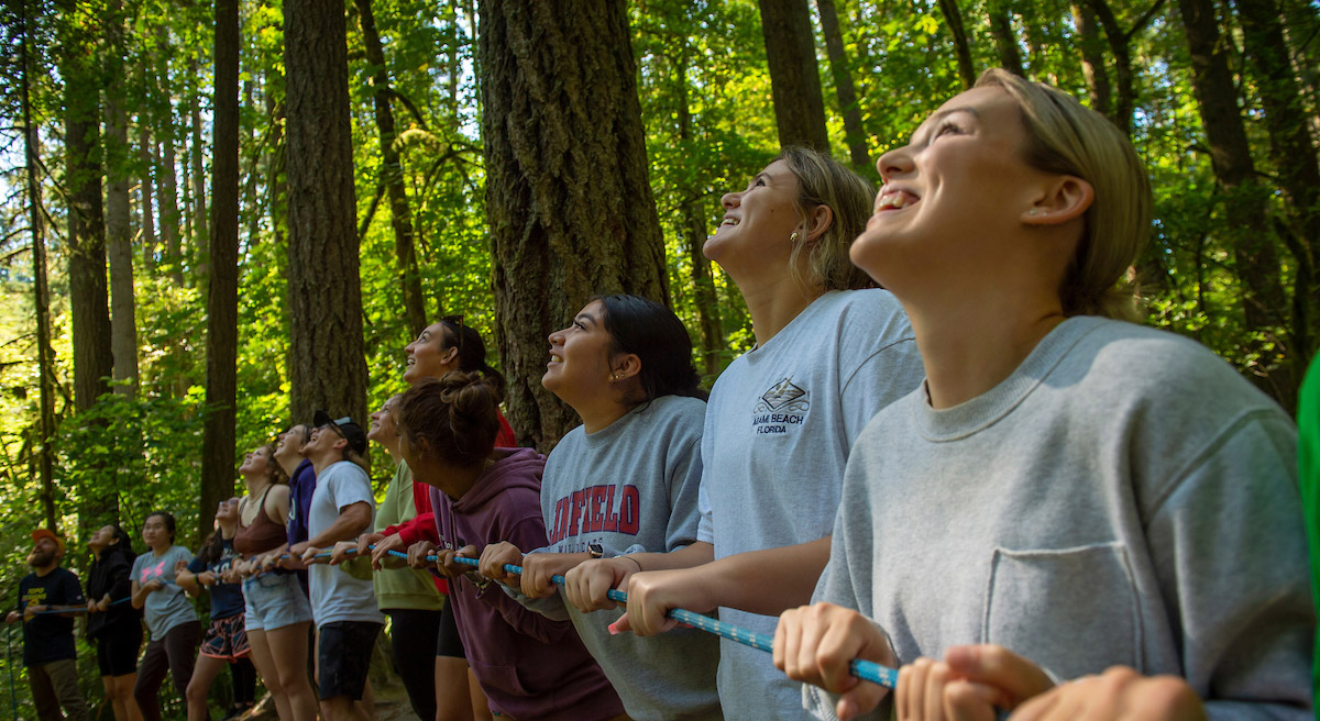 Students doing a trust exercise holding a rope during the Ignite pre-orientation program.