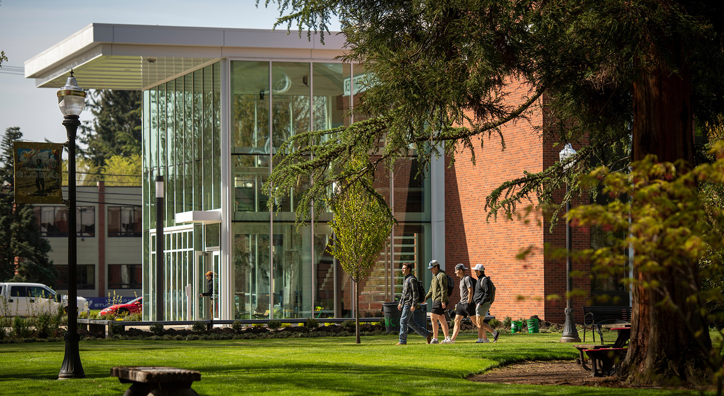 Group of students walking on the path along the side of W.M. Keck Science Center.