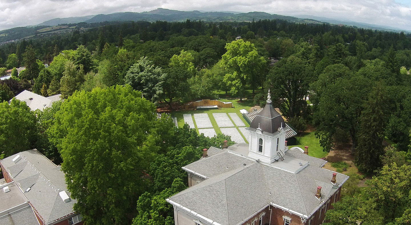 An aerial view of the Oak Grove over Pioneer Hall staged for Commencement.