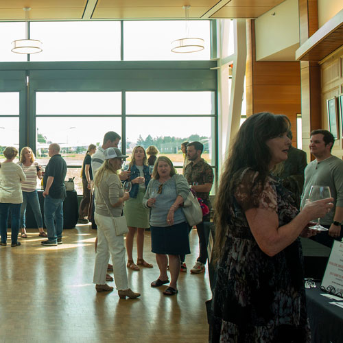 Oak & Vine members mingling and tasting wine in Evergreen Aviation Museum