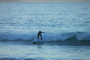 Surfing at Aramoana; this beach is situated on the western side of the entrance to Port Otago, South Island of New Zealand. The sand bottom beach break is known for its hollow and powerful waves produced from wedging peaks.