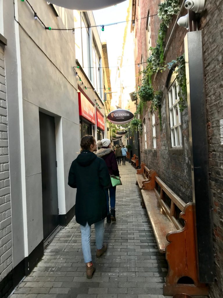 Kristen Burke and Paige Phillipson strolling through a Belfast alley