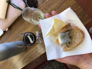cheese on slice of bread with wine in the background