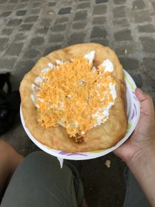 langos on a plate held by a hand