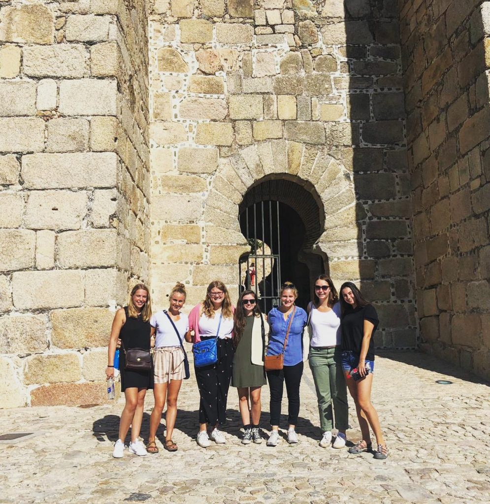 Students in front of stone castle in Spain.