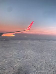 plane wing over clouds during sunrise