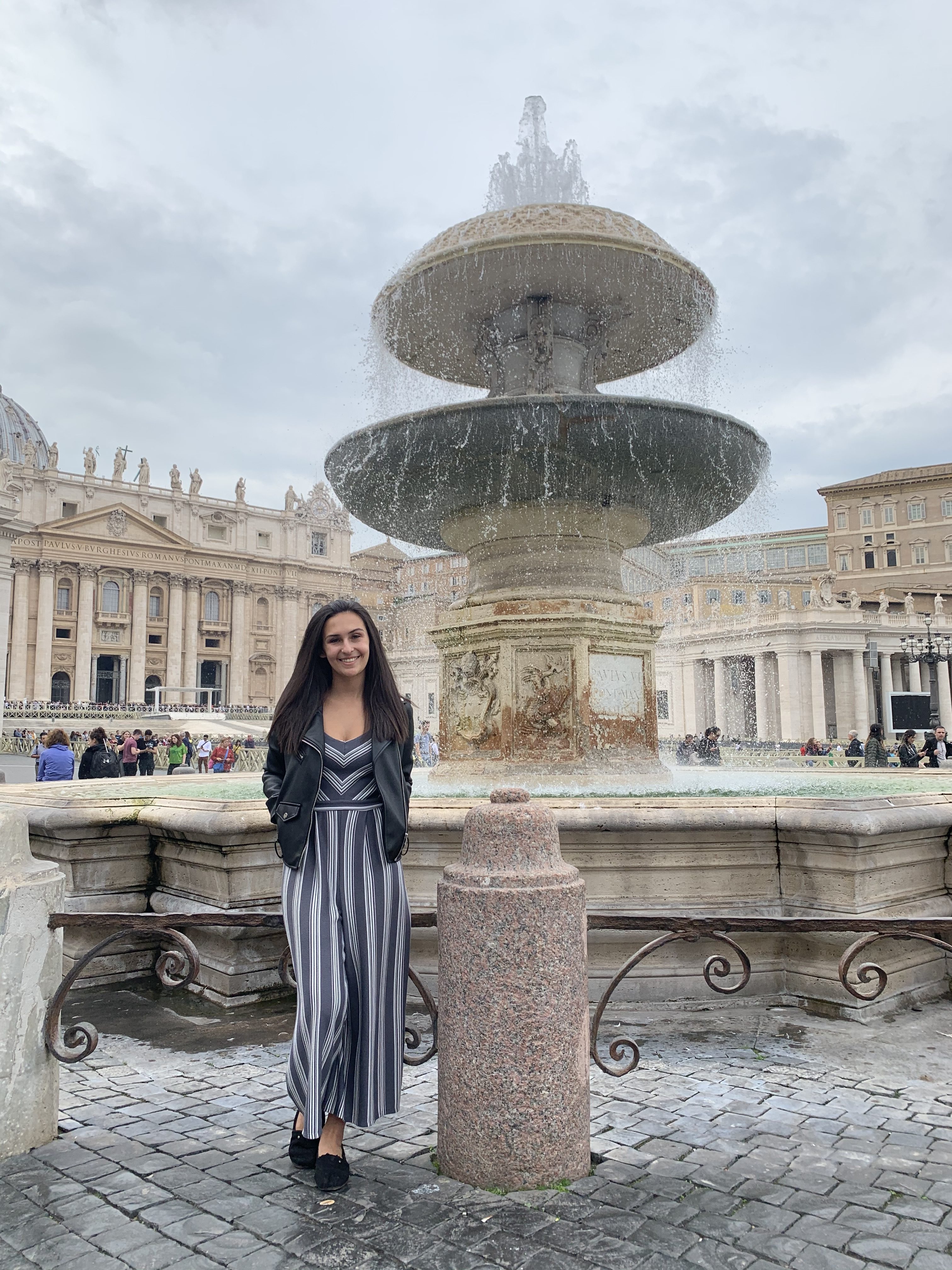 Me outside of the Vatican standing in front of a large fountain.