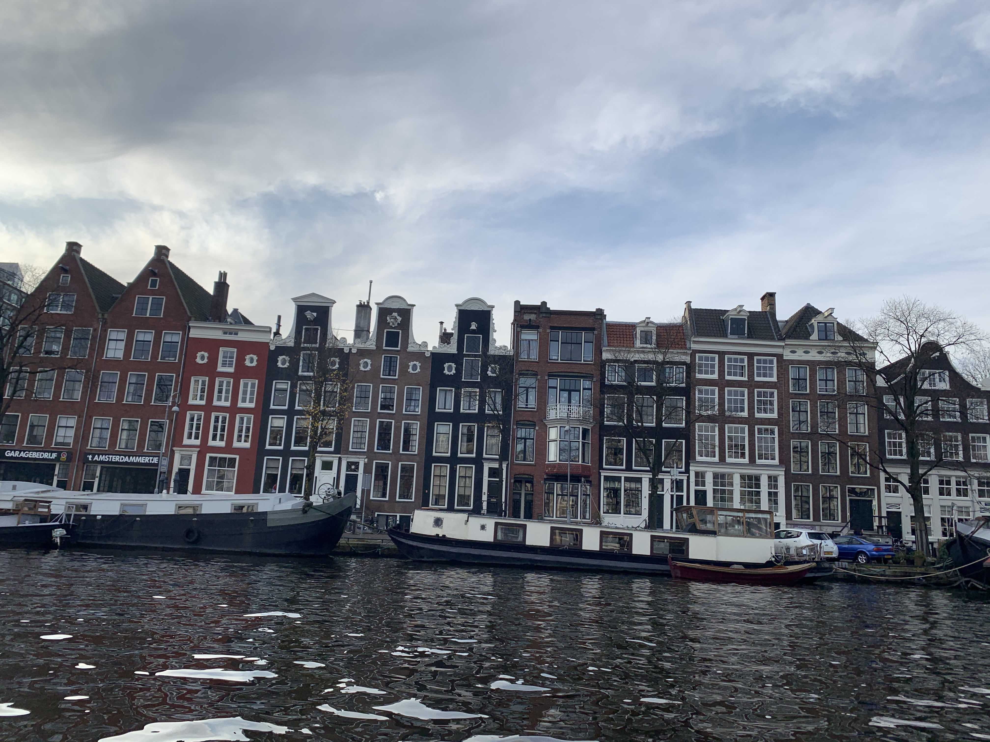 Typical buildings in Amsterdam on a canal lined with barges