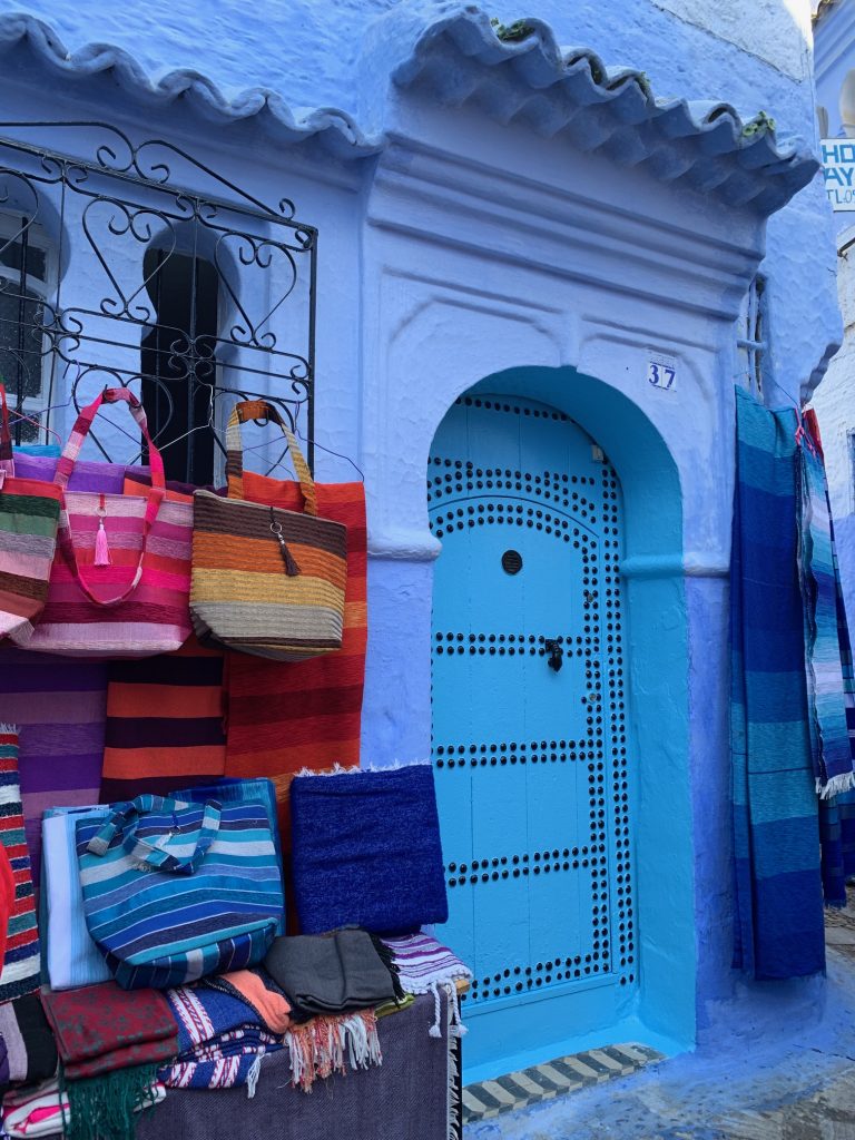 Chefchauen, Morocco; selling rugs and bags.