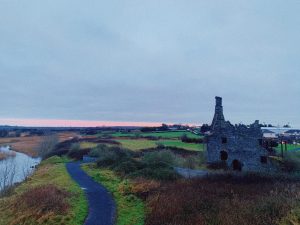 Terryland Castle in Ireland surrounded by flat green fields.