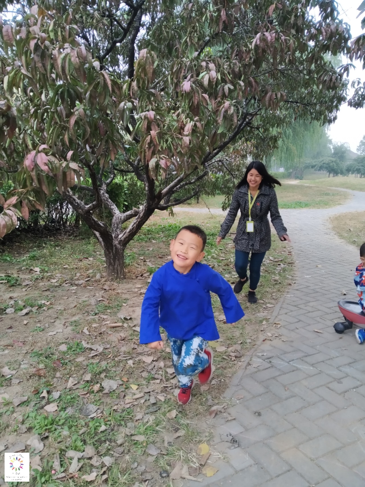 Playing with a child at the learning center visit, running under a tree.